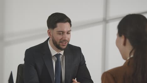 Male-Candidate-Being-Interviewed-In-Office-For-Job-By-Female-Interviewer-Viewed-Through-Window-9