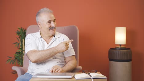 the old man promoting is pointing to the side and laughing.