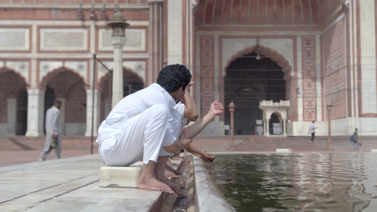 hombre musulmán indio haciendo rituales de wuzu en una mezquita