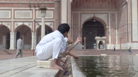 hombre musulmán indio haciendo rituales de wuzu en una mezquita