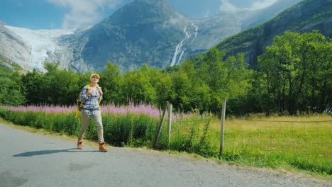 the woman admires with admiration the beautiful nature of norway walks along the path against the ba