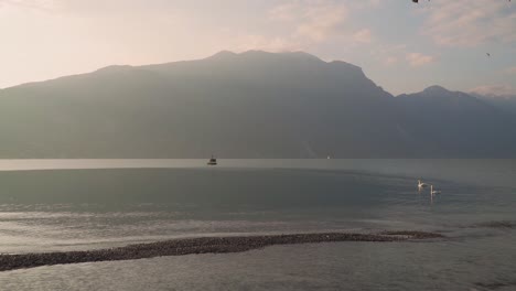 Luz-Mística-Del-Amanecer-En-La-Montaña-Solitaria,-Mañana-Dorada,-Orilla-Vacía-Del-Lago-Garda