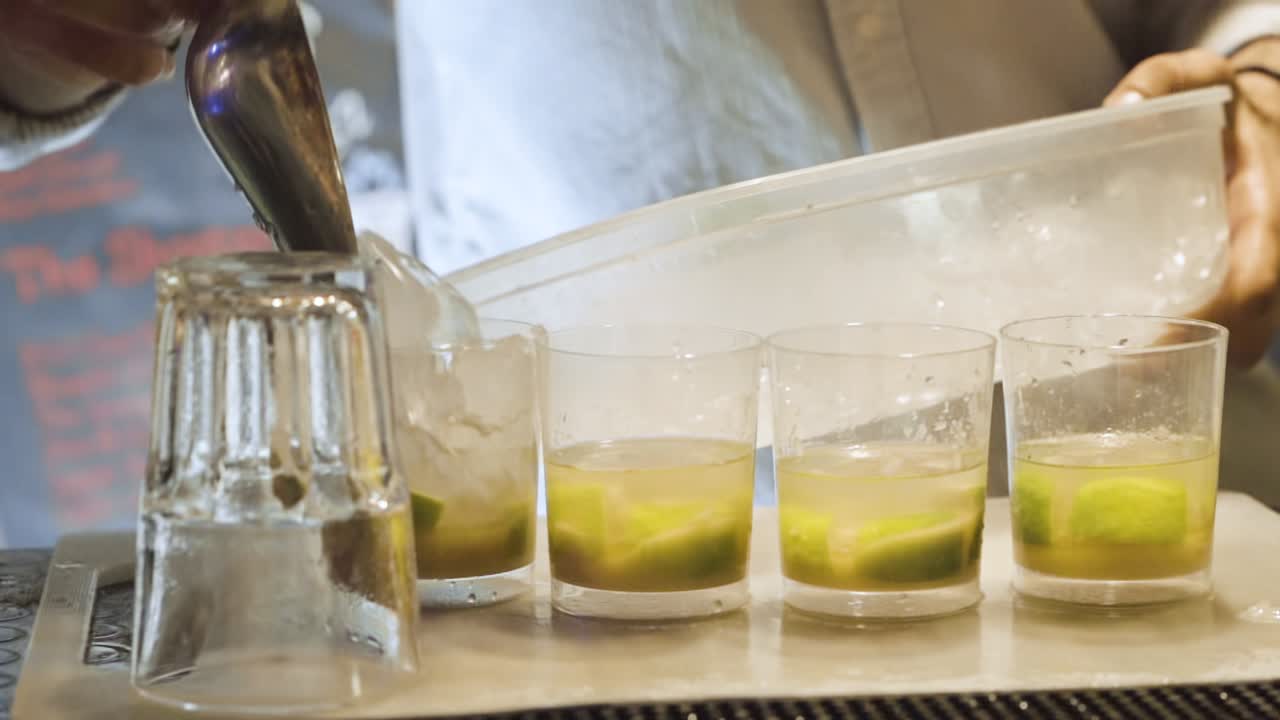 barman vertiendo hielo picado en tazas en un bar