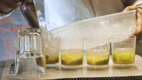 barman pouring crushed ice into cups in a bar