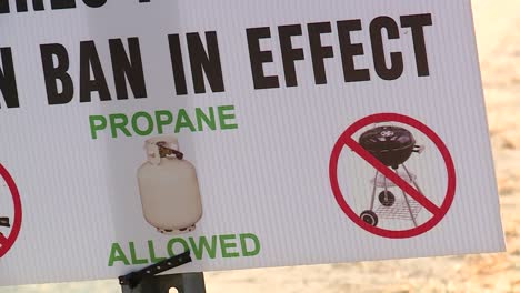 panning shot of burn ban sign along road