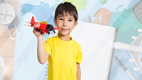 animation of happy caucasian boy playing with plane toy over map