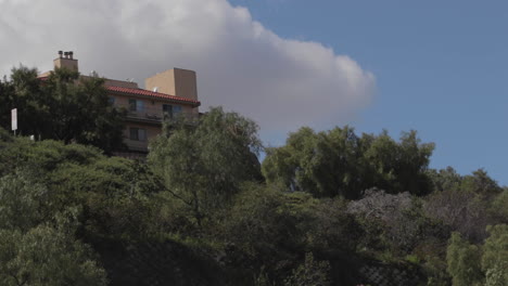 edificio en la cima de una colina con nubes y un avión