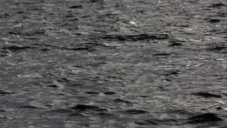 Natural-water-background-with-ripples-and-shadows-reflecting-on-peaks