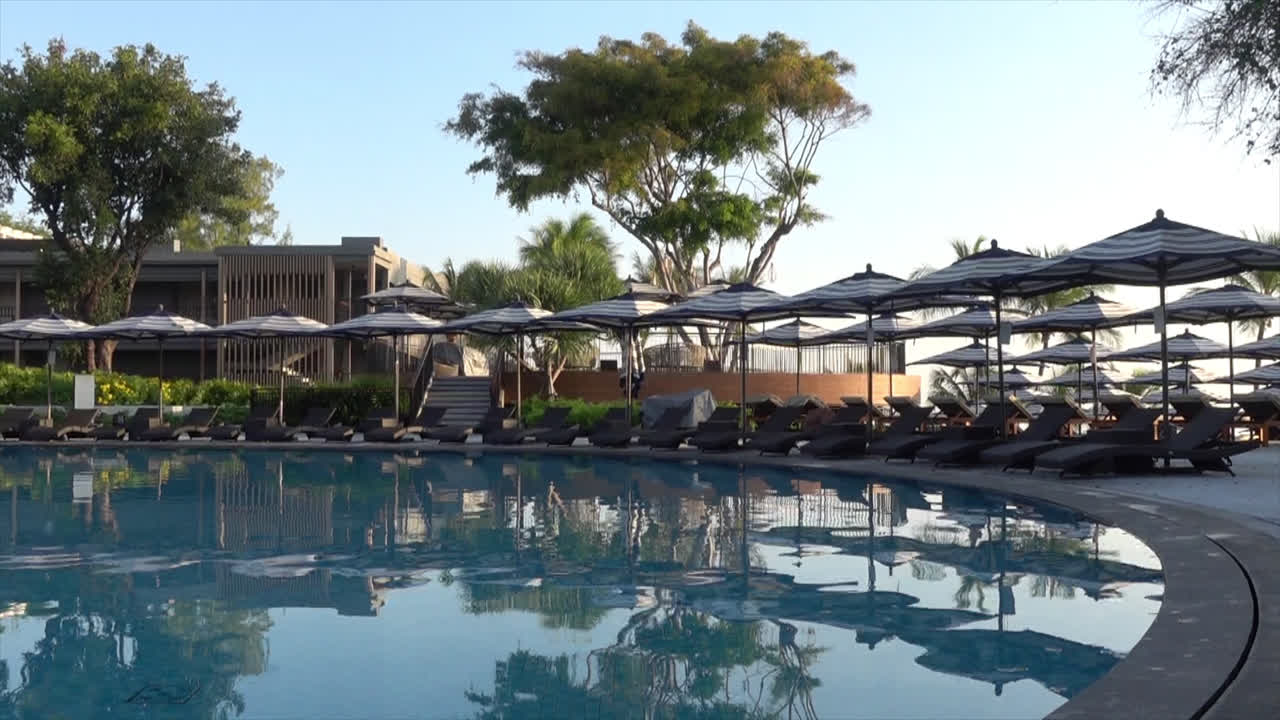 여행 휴가 휴가 개념-4를 위한 호텔 리조트의 야외 수영장 주변의 파라솔과 수영장 침대