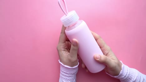 pink water bottle in hands