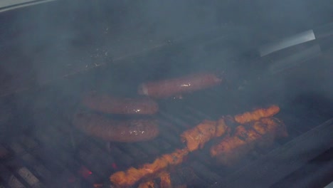 Mirando-Las-Salchichas-Y-El-Pollo-Sate-Recibiendo-El-Calor-Y-El-Humo-De-La-Barbacoa