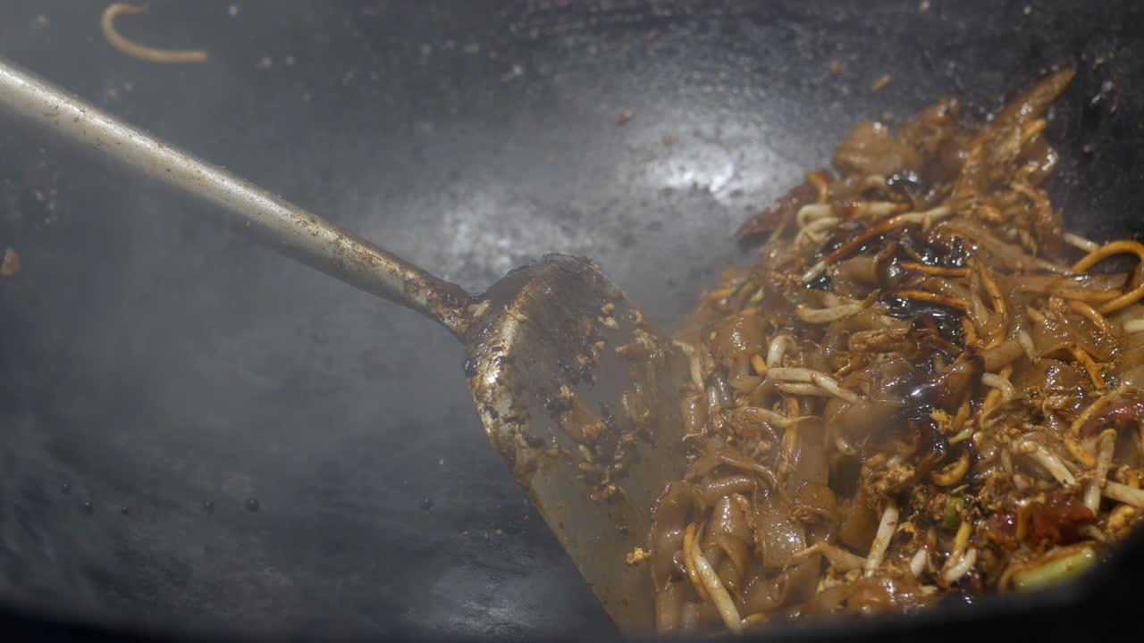 Primo piano di noodle e germogli di soia saltati in un wok caldo