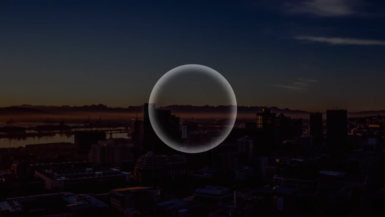 Circular shape animation over cityscape at dusk with mountains in background