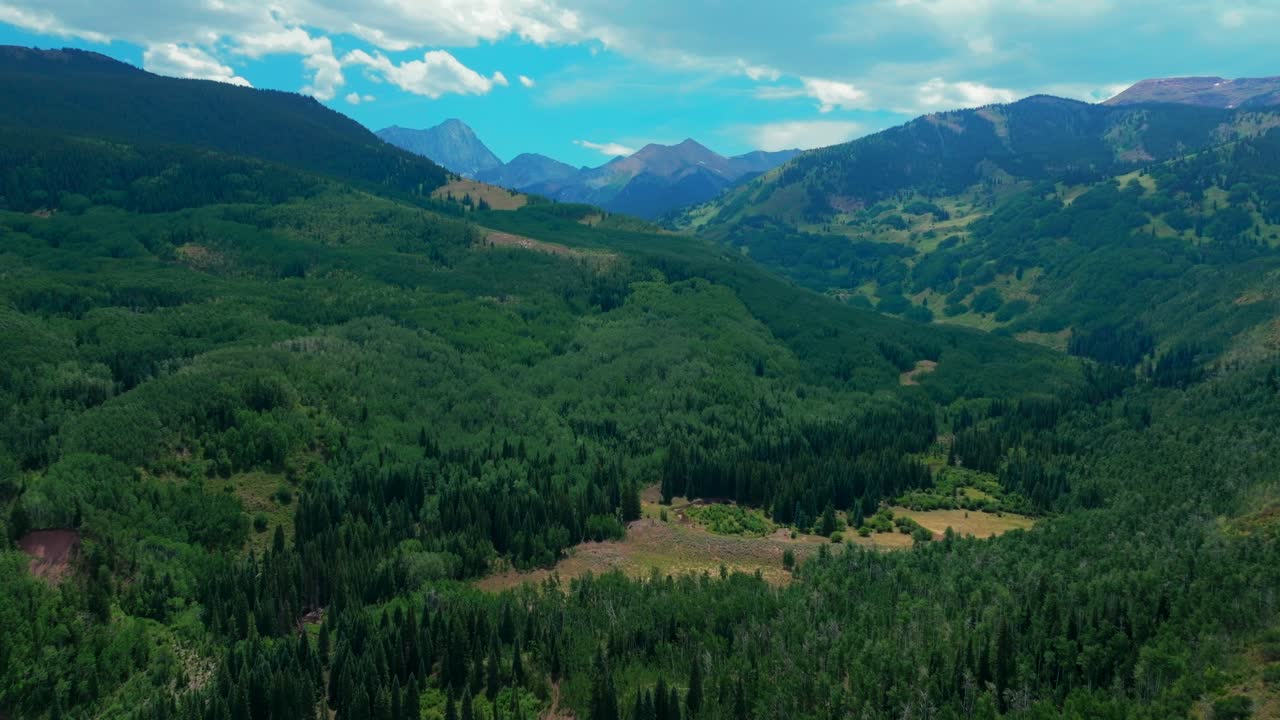 Capitol creek ditch trail Capitol Peak Wilderness spring summer 14er aerial drone Colorado Aspen Snowmass K2 Elk Rocky Mountains Range Aspen grove White River Forest sunny blue sky forward pan up