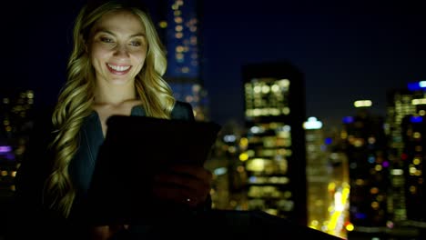 mujer de negocios estadounidense caucásica usando tecnología de pantalla táctil por la noche