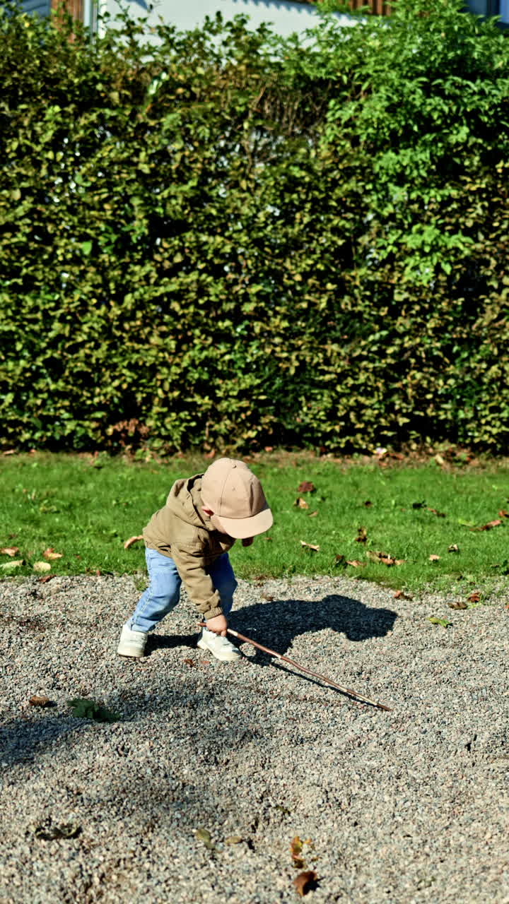 Cute 2 year old boy playing outside and developing. Toddler on a walk outdoors. Child playing on the playground