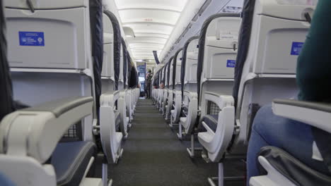 asientos de avión en clase económica antes del despegue, vista a través del pasillo