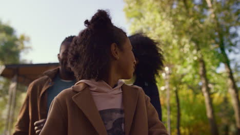 retrato de una hija feliz caminando por el parque con padres sonrientes. concepto familiar idílico.