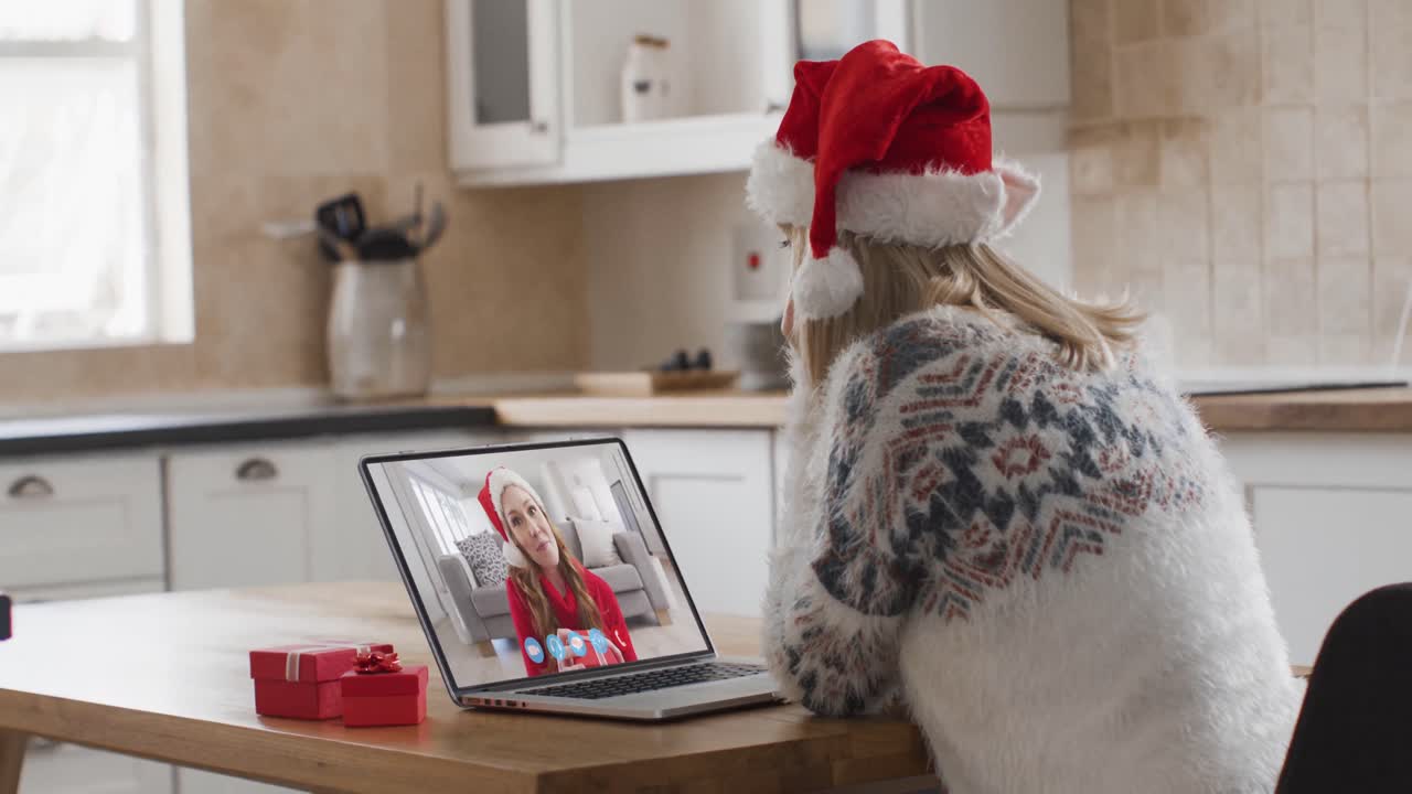 mujer caucásica teniendo una videollamada de navidad con su familia