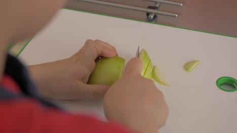 niño cortando una manzana