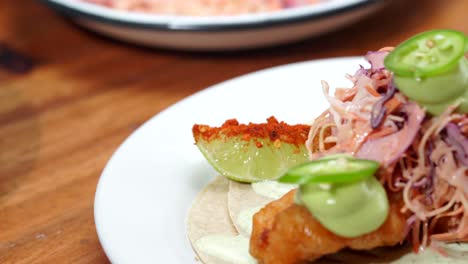 latin chef putting lemon with chilli on shrimp taco baja california style