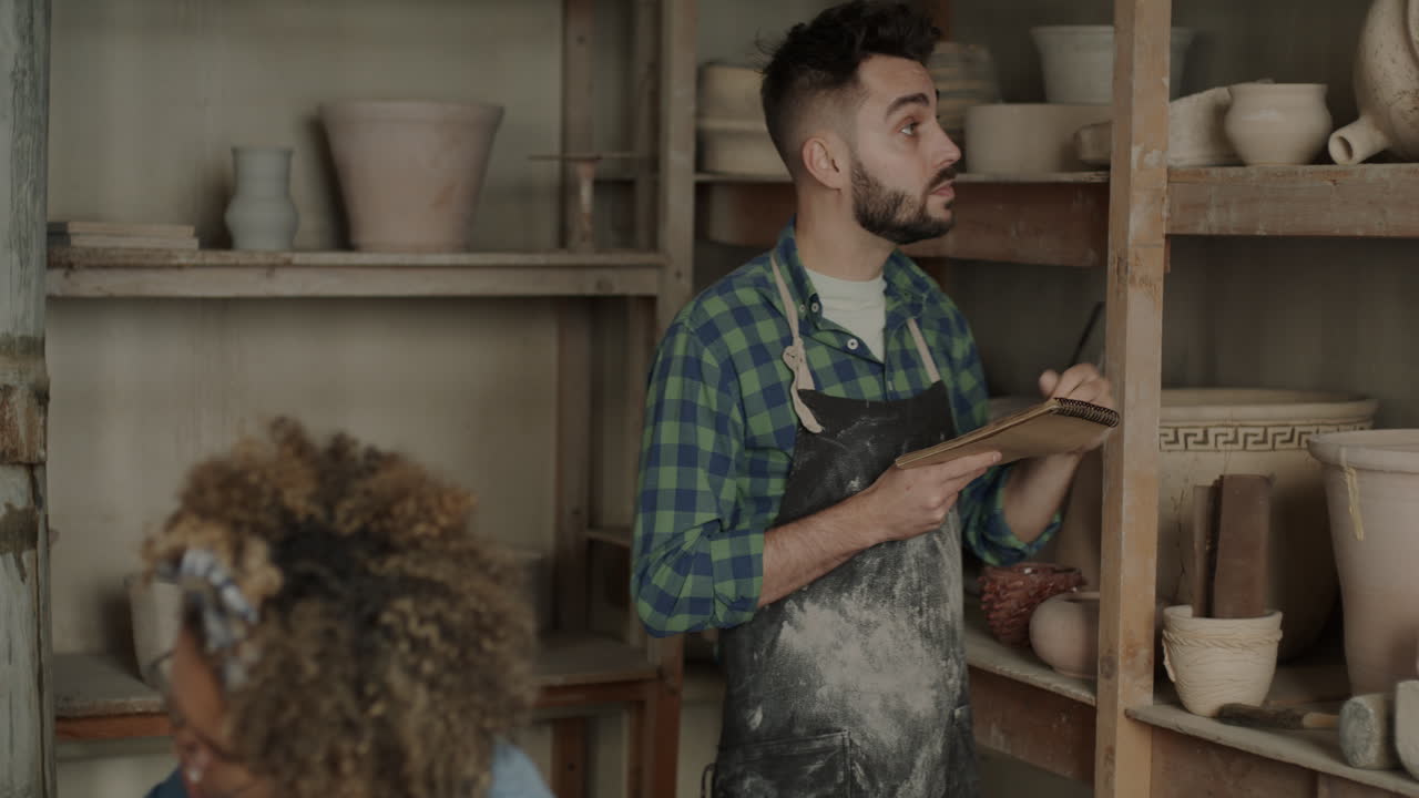 Ceramista che Prende Appunti nel Laboratorio