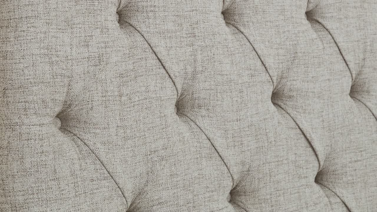 Camera moves over upholstered headboard texture in bedroom