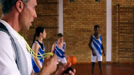 entrenador de baloncesto entrenando a niños de secundaria 4k