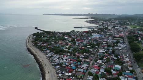 Vista-Aérea-Panorámica-De-La-Ciudad-Costera-De-La-Isla-Con-Una-Idílica-Bahía-Oceánica,-Calles-Y-Casas-Concurridas