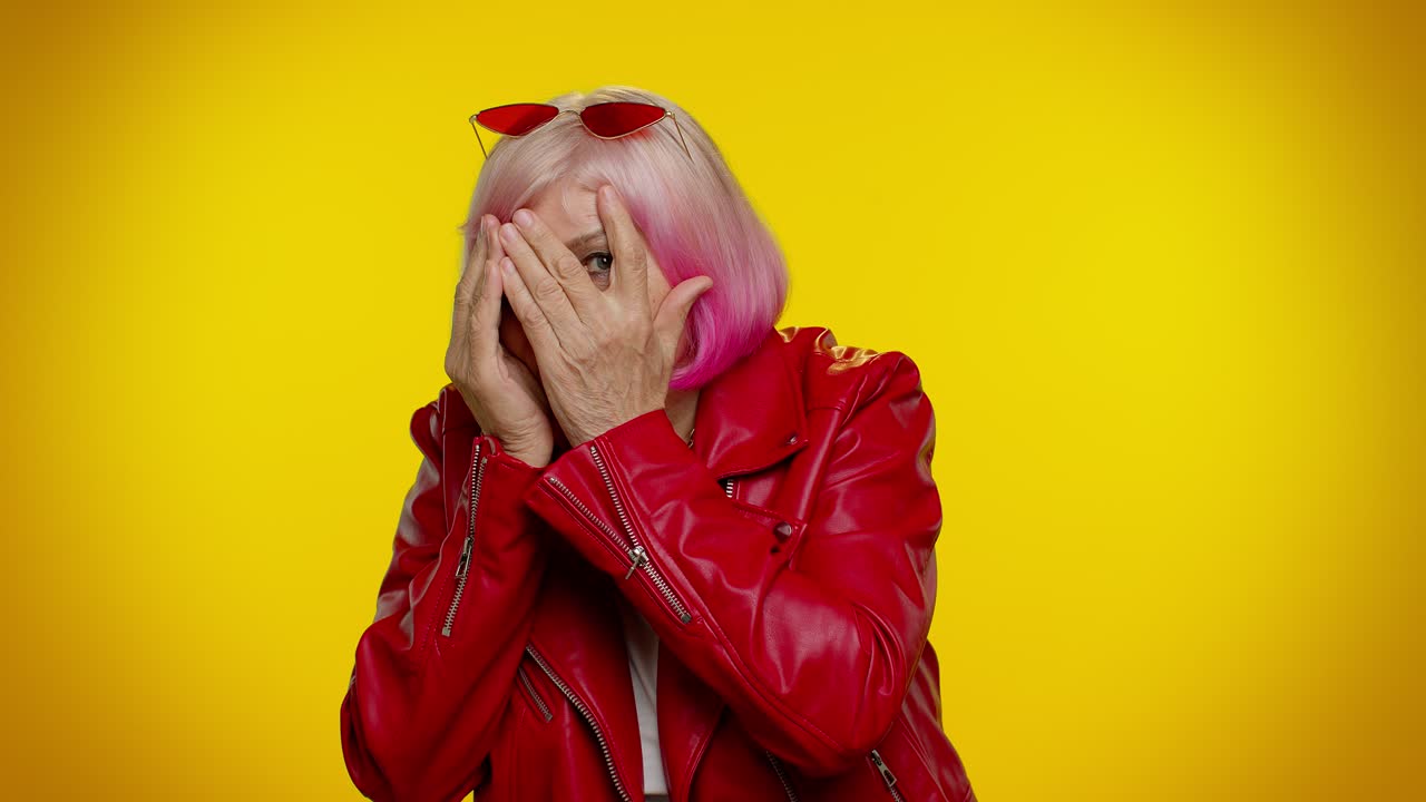 curiosa abuela anciana cerrando los ojos con la mano, espiando a través de los dedos, escondiéndose, espiar