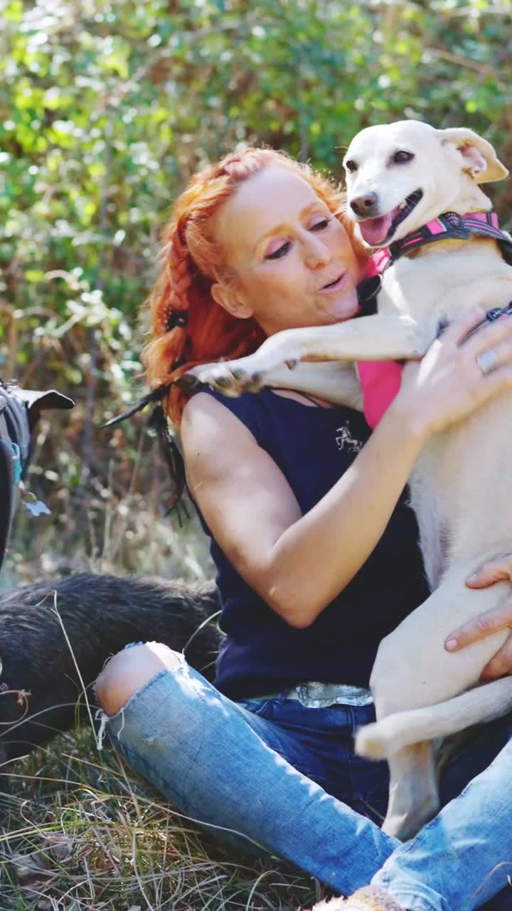 A heartwarming interaction between a woman and her beloved dogs outdoors
