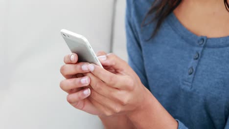 smiling woman texting on the sofa