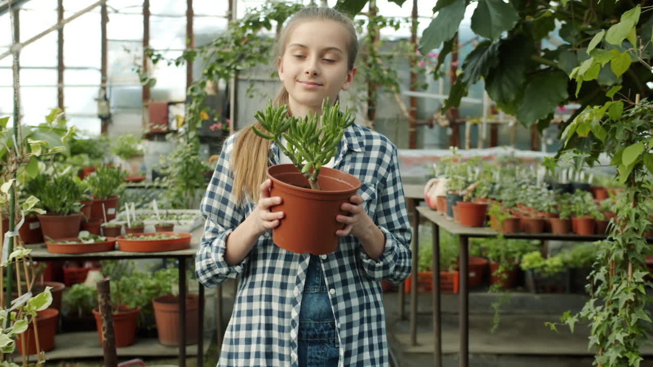 Girl Holding Succulent Plant in a Greenhouse