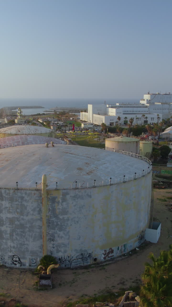 The Reading Power Station and fuel storage tanks in Tel Aviv at sunset. The warm hues contrast with the industrial site, creating a unique coastal cityscape - Vertical video