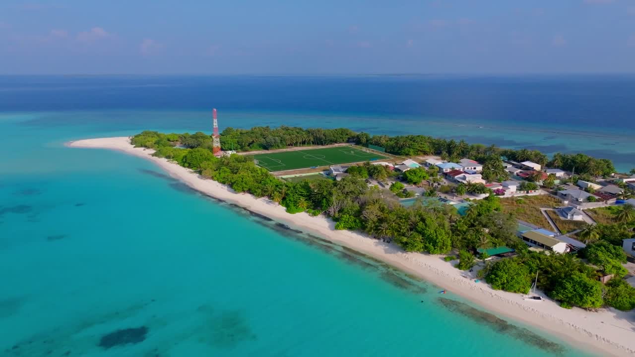 Hermosas imágenes aéreas de dron volando sobre el lado norte de la isla Vashafaru con una vista clara de toda la isla hasta la costa sur en el norte de Maldivas.