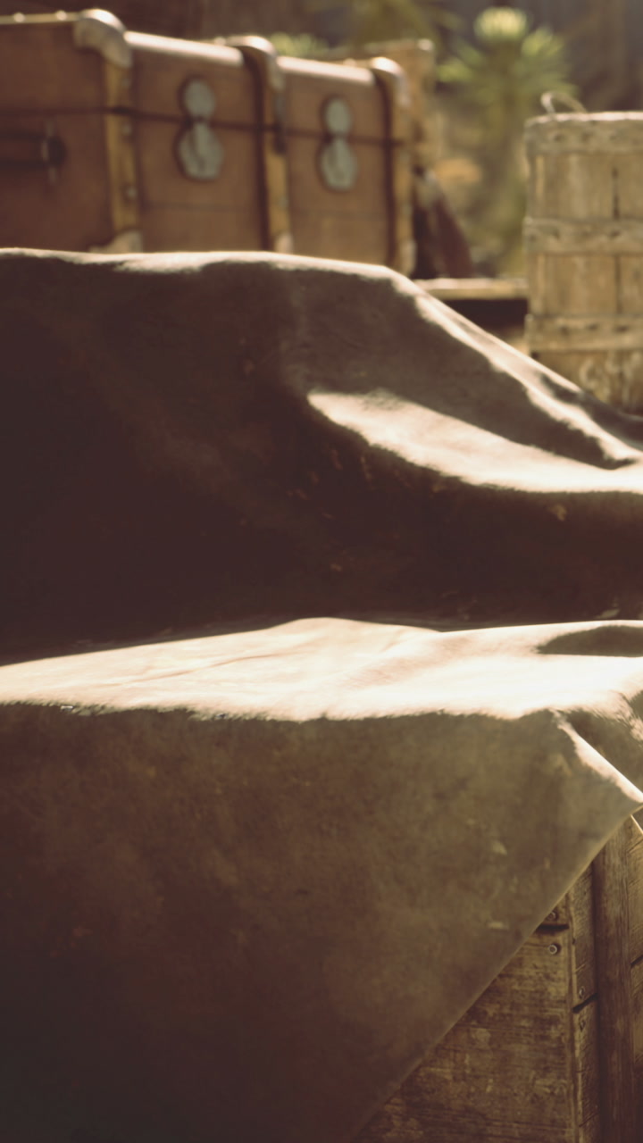 Exploring an old wooden table draped with a weathered cloth near vintage trunks