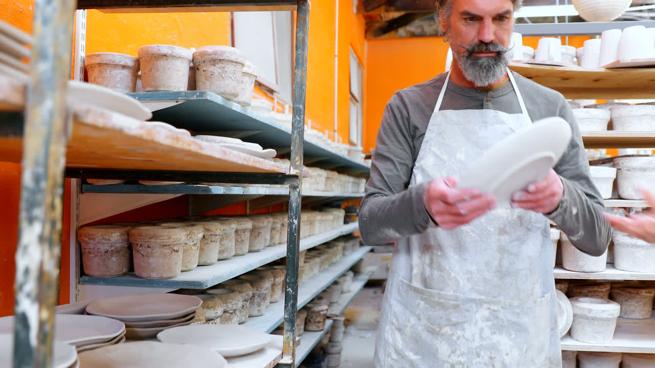 alfarero masculino interactuando entre sí en el taller de cerámica 4k