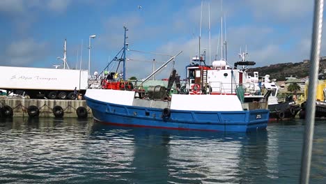 small fishing vessel docked in calm harbour