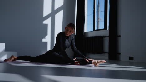 woman doing a split stretch in a yoga studio