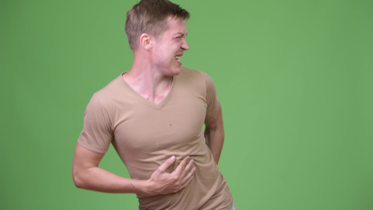 Young handsome Scandinavian man having stomach ache and looking for the bathroom