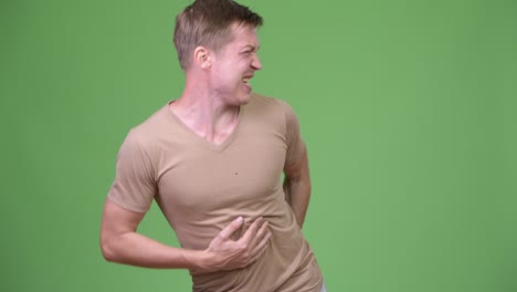 young handsome scandinavian man having stomach ache and looking for the bathroom