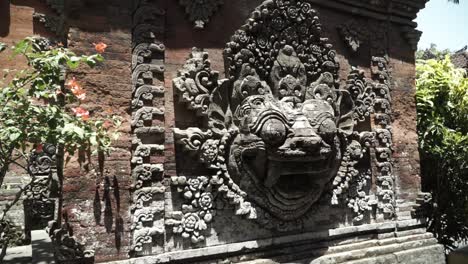 this is in ubud palace, mythology animal face on the wall with the flowers