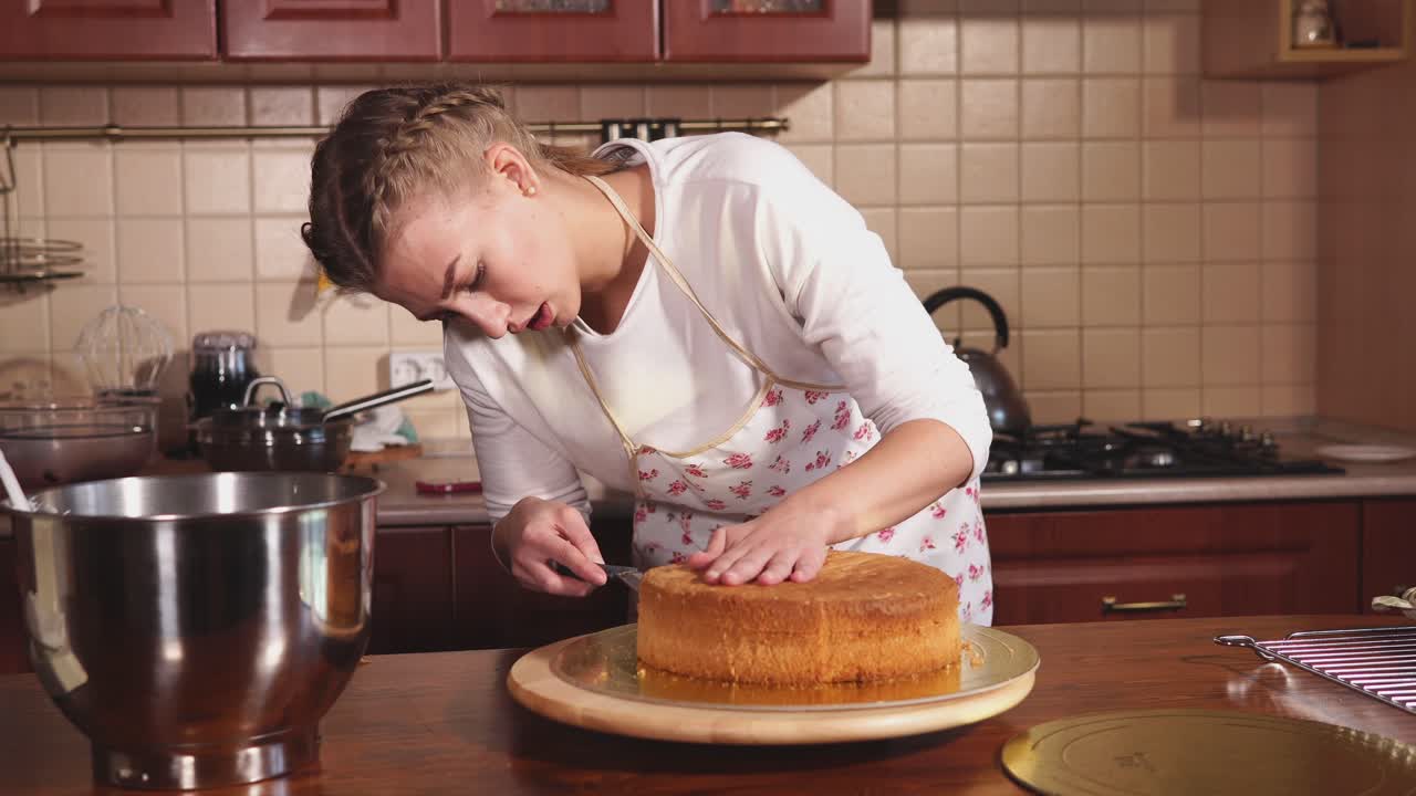 Nainen leipomassa kerroskakkua keittiössä