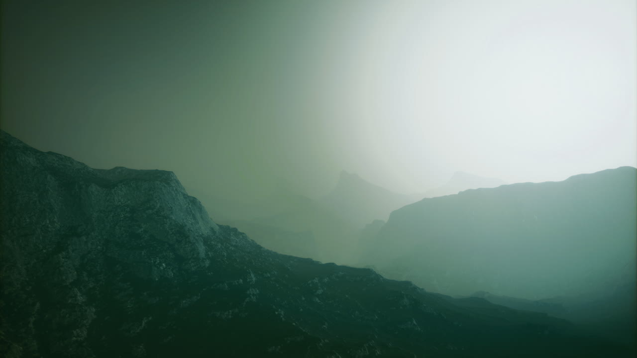 Mountain landscape enveloped in mist during early morning hours