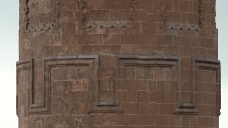 The-camera-tilts-the-historical-minaret-of-Mardin-Ulu-Mosque,-made-of-cut-stone,-from-bottom-to-top