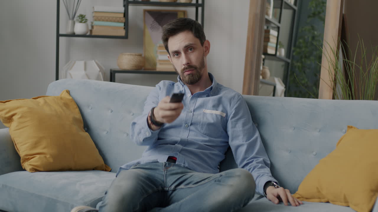 Man Relaxing on a Couch, Watching TV