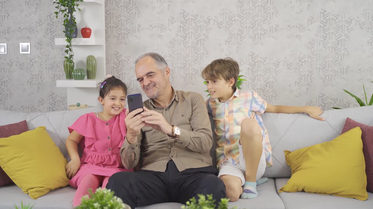 dede está chateando por video con sus nietos por teléfono.