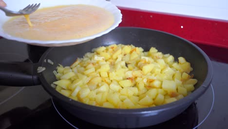 Poner-Huevo-Batido-En-Una-Sartén-Con-Patatas-Y-Cebolla.