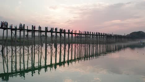u bein puente con puesta de sol roja detrás revelando barcos tradicionales en el río