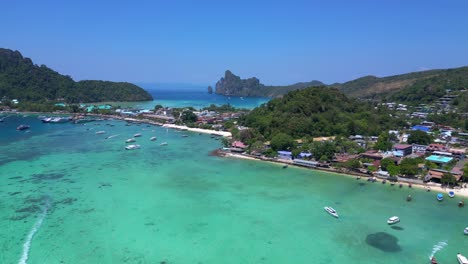 Vista-Aérea-De-La-Isla-Phi-Phi-Con-Aguas-Turquesas,-Barcos,-Complejos-Turísticos-De-Lujo-Y-Paisajes-Montañosos